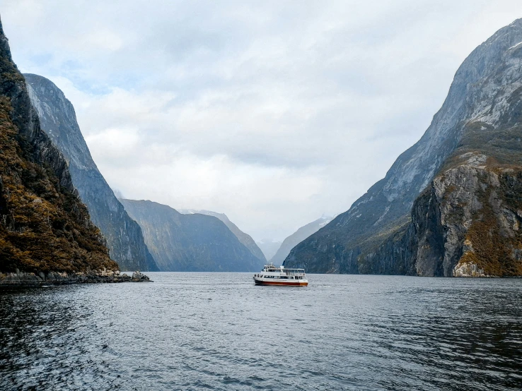 a boat in the water near tall mountains