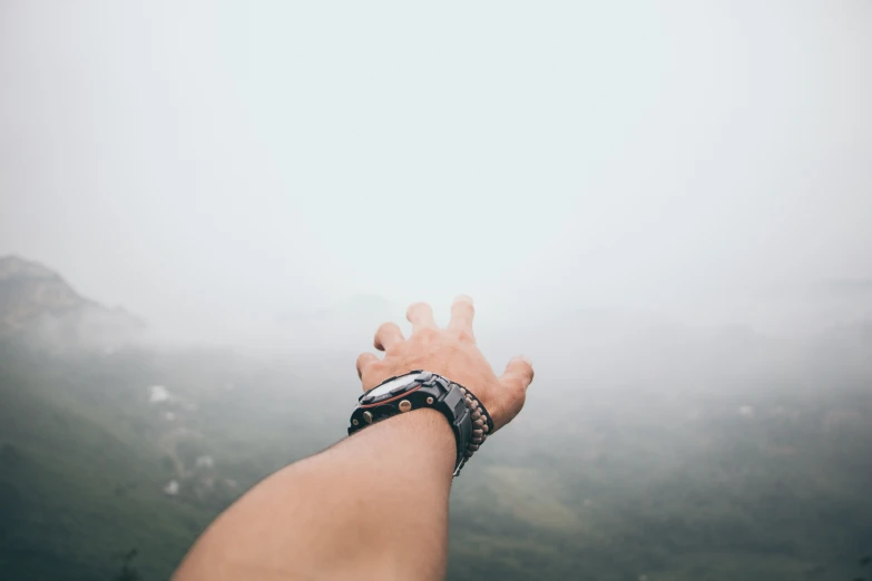 a hand with an airplane flying in the background