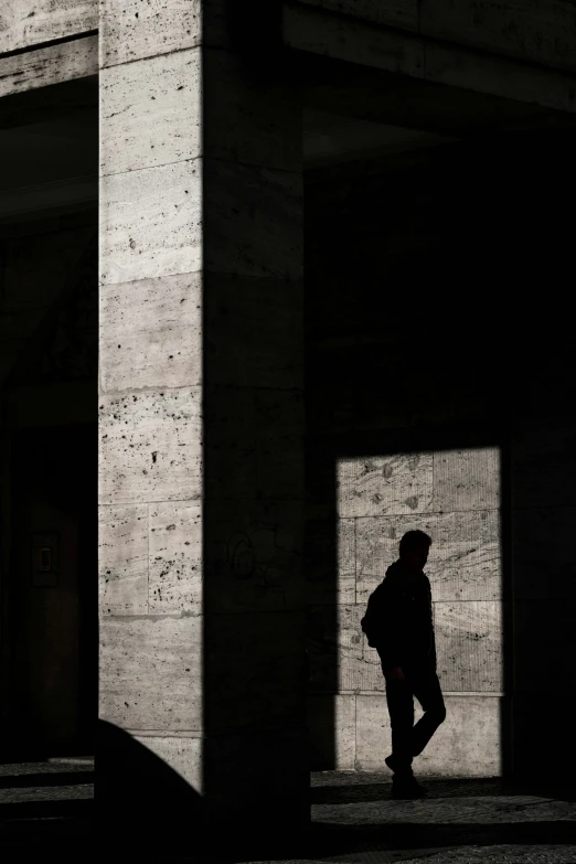 a person in shadow stands in front of an entrance