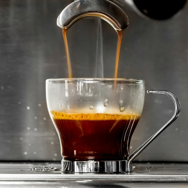 coffee pours into a cup with  liquid