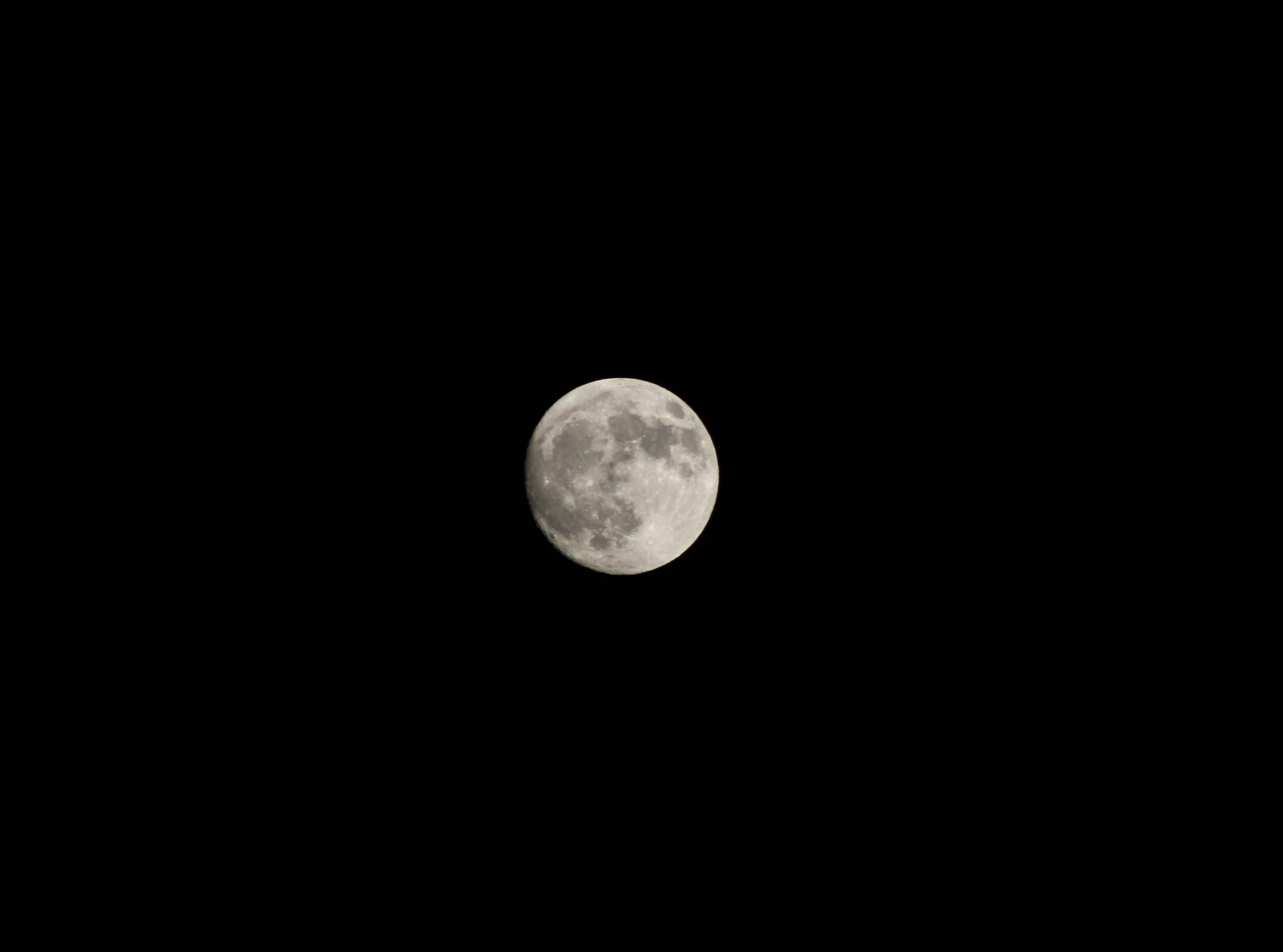 a full moon with black sky behind it