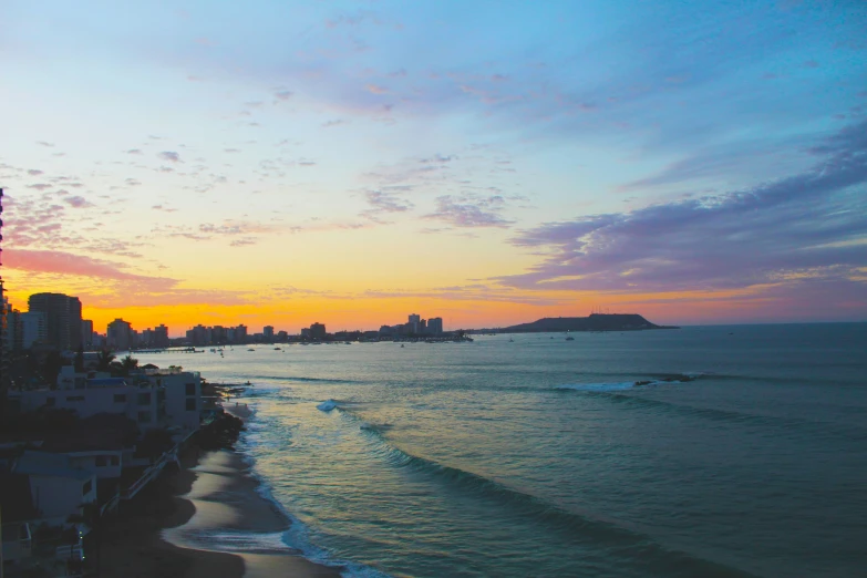 the sunset over an ocean, with water sports coming in