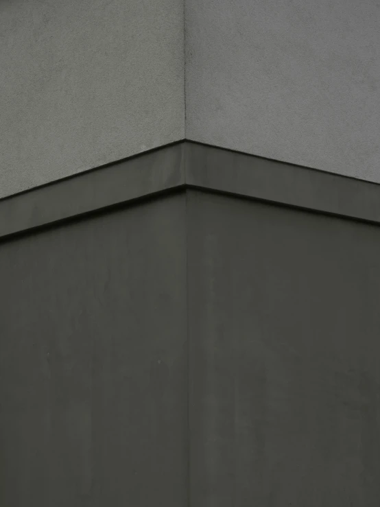 a person standing on the corner of a building holding a surfboard