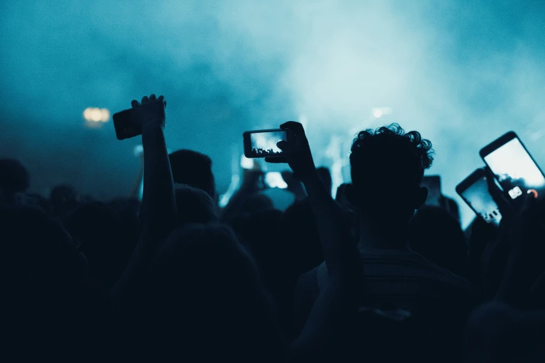 some people holding up their phones at a concert