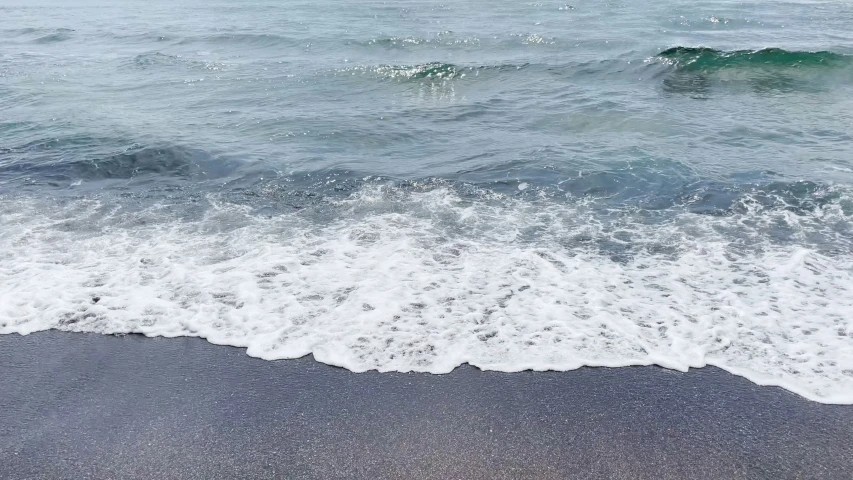 the waves are rolling in the beach shore