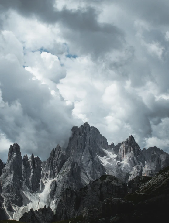 a group of mountains under clouds and blue sky