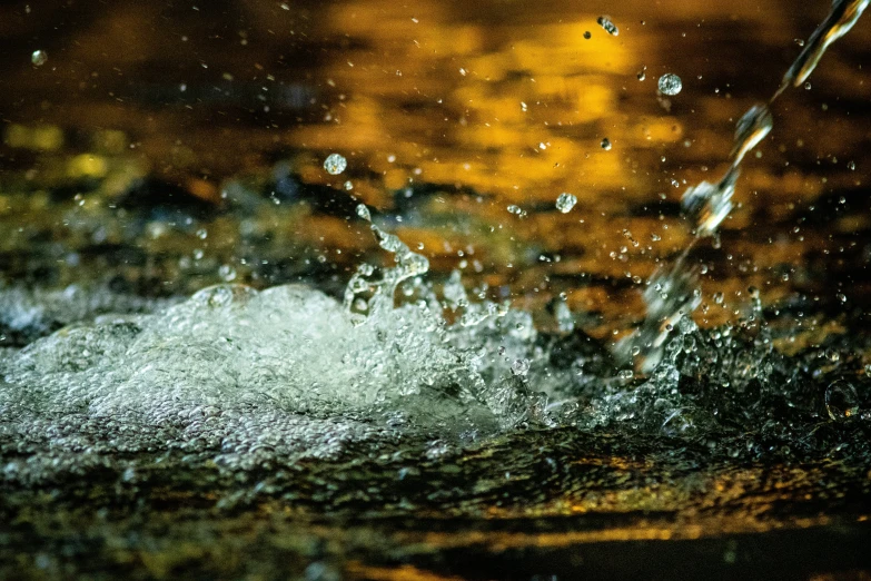 a close up of water with drops of water coming off the surface