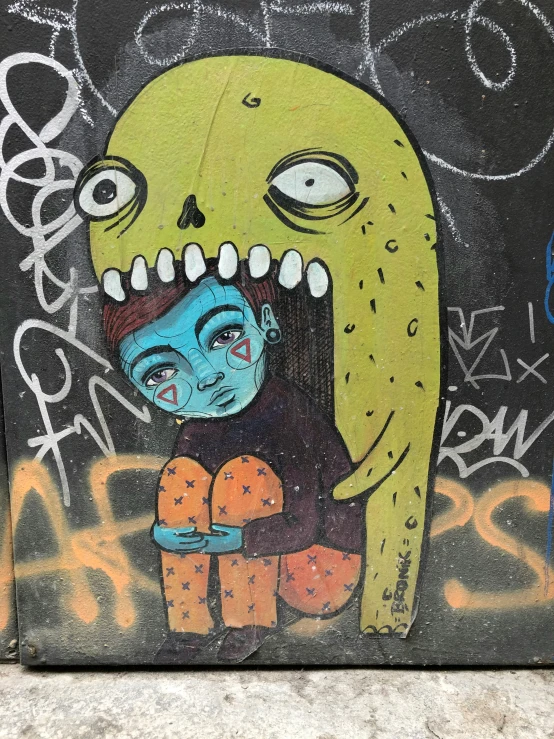 a painted image on concrete of a monster holding a child