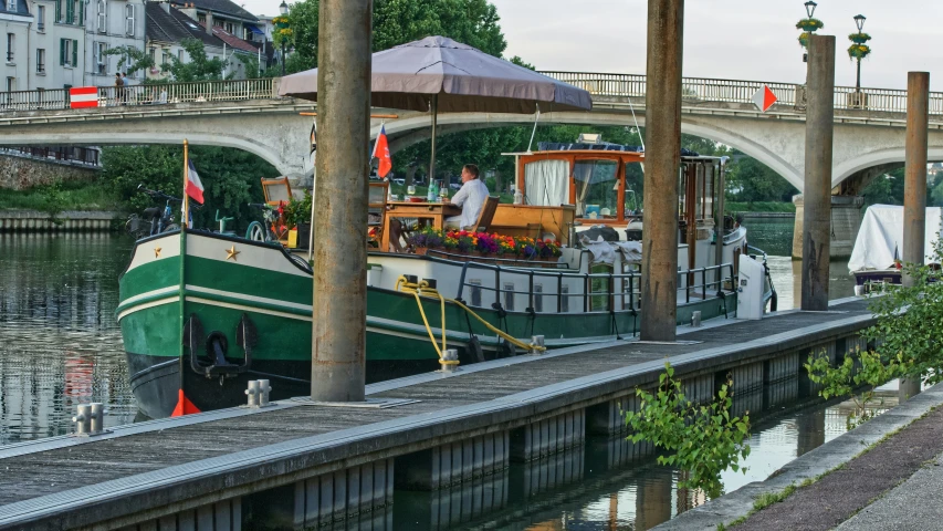 a green boat parked in the middle of a canal