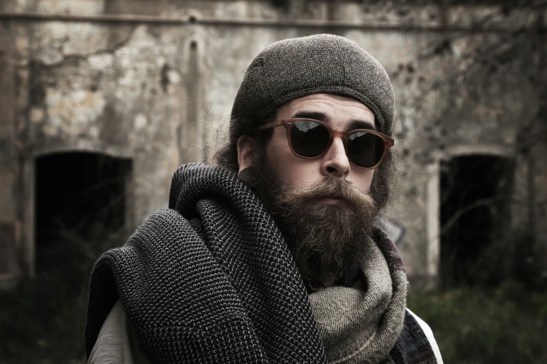 a man with glasses and a beard wearing a scarf