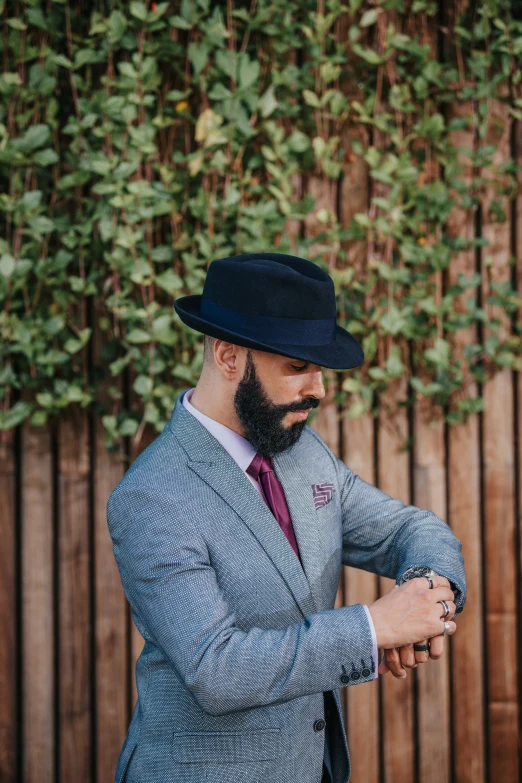 a man wearing a hat and holding his tie