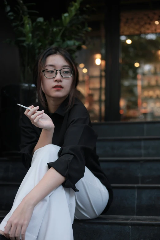 a person sitting on steps holding a cigarette