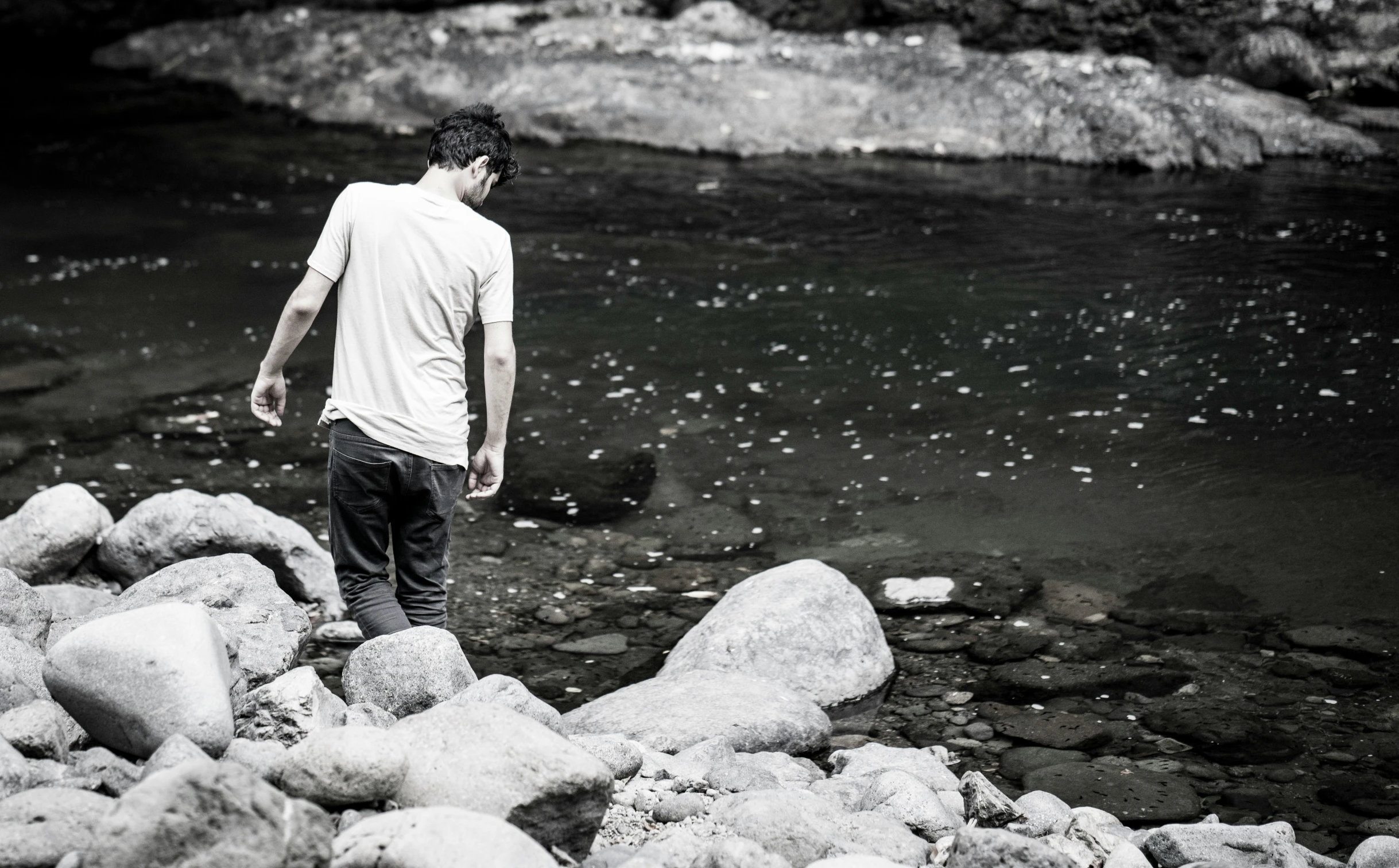 a man standing on a rock and looking across a river