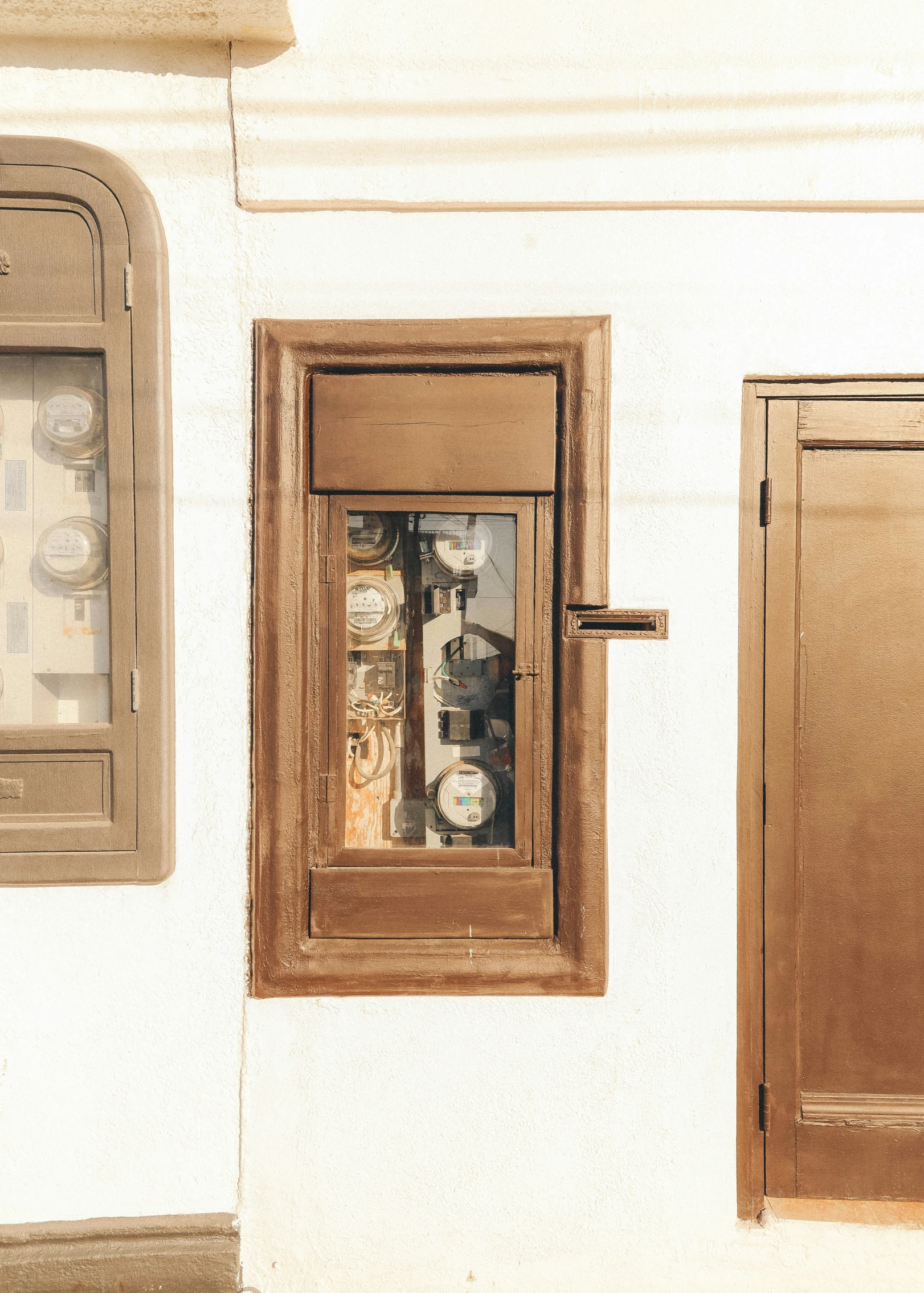 two windows on the side of a building with clocks