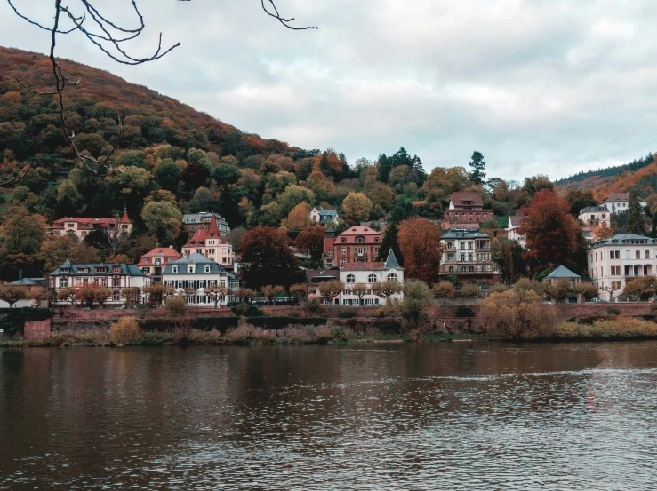 a body of water near a large hill with buildings on it