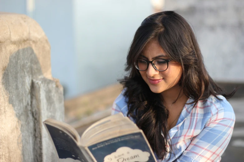 a woman reading a book in the sunlight