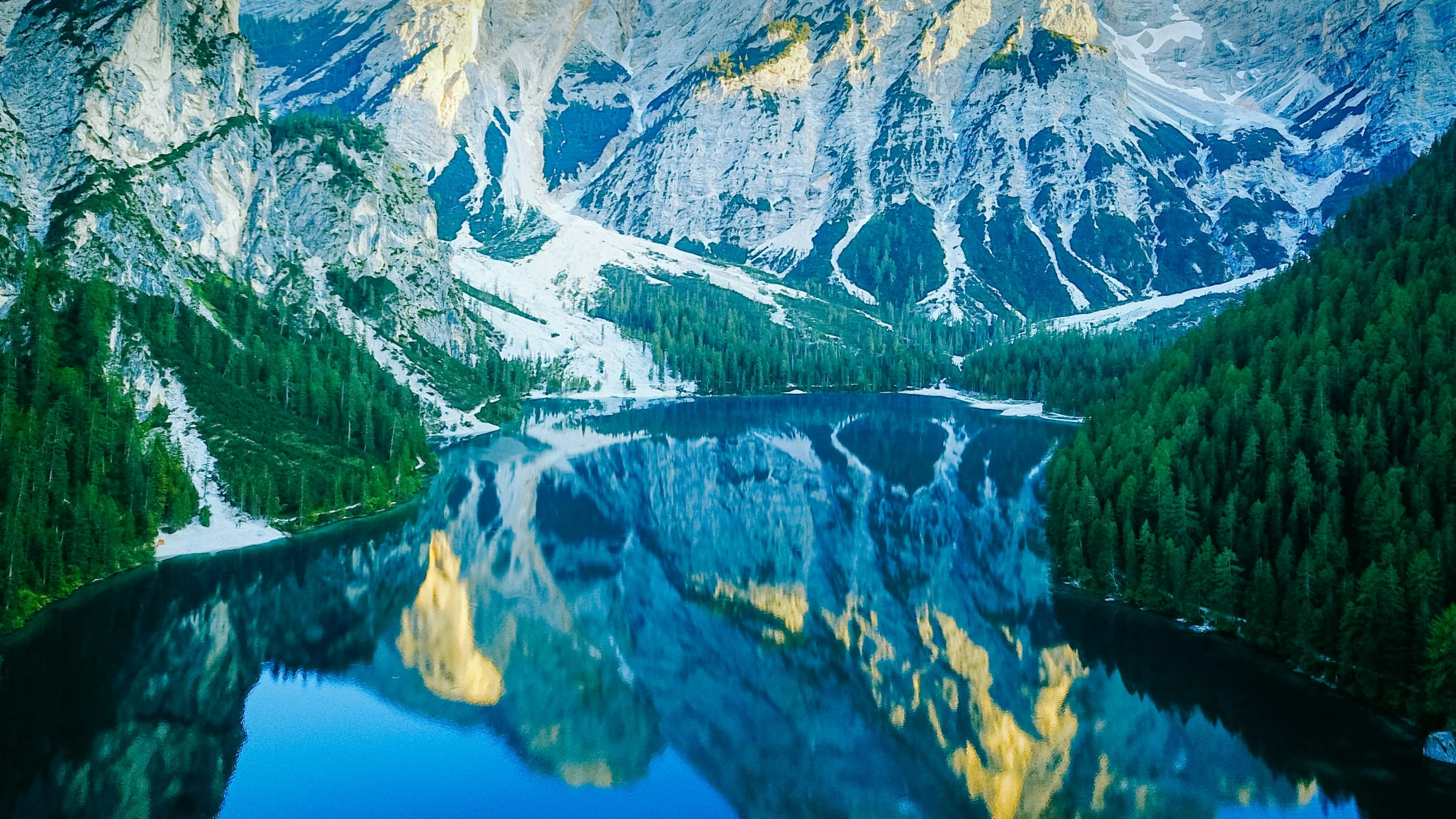 mountain range and lake covered in snow with reflections