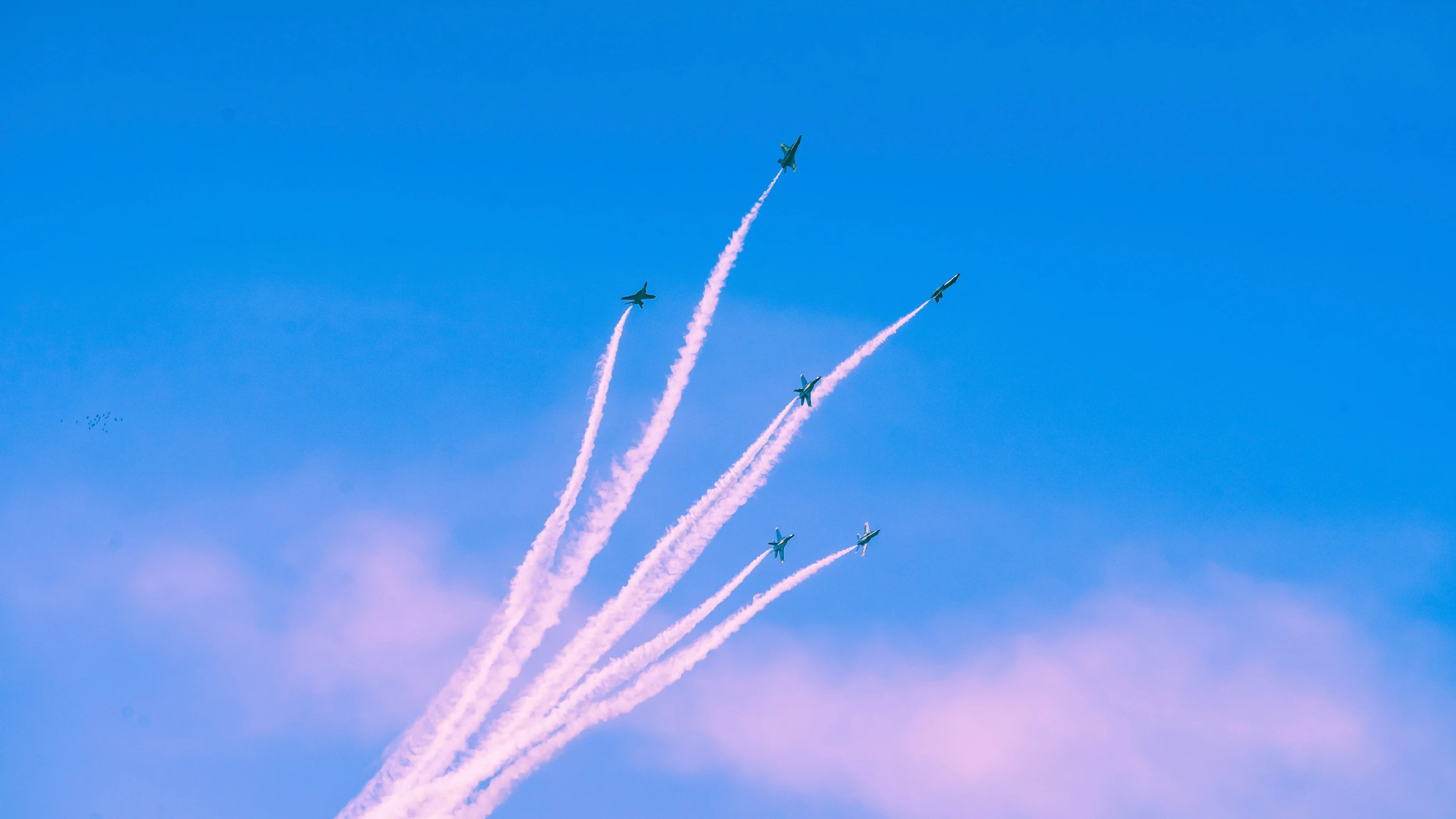 several airplanes fly in formation in a cloudy sky