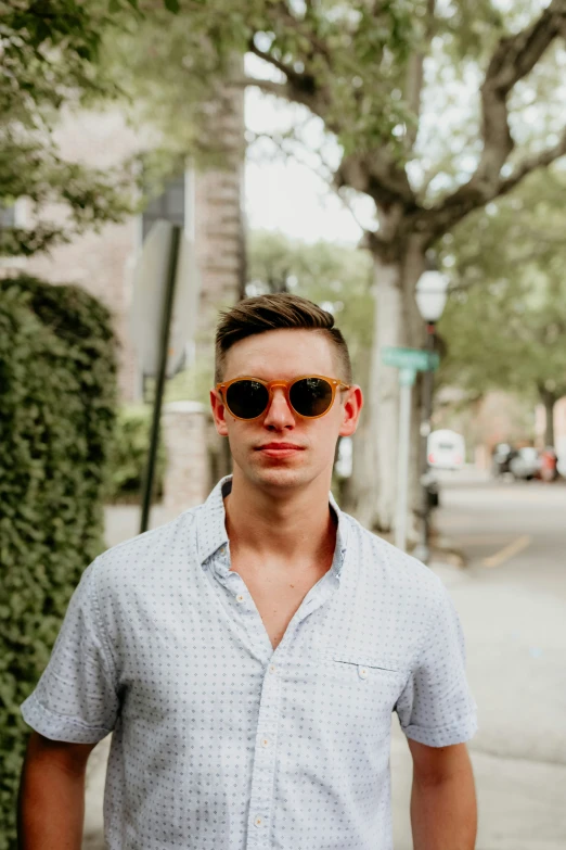 a man wearing sunglasses is standing by the street