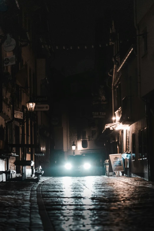 a car driving down a street at night in the dark