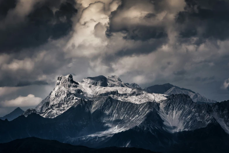 mountains with snow on them and dark clouds