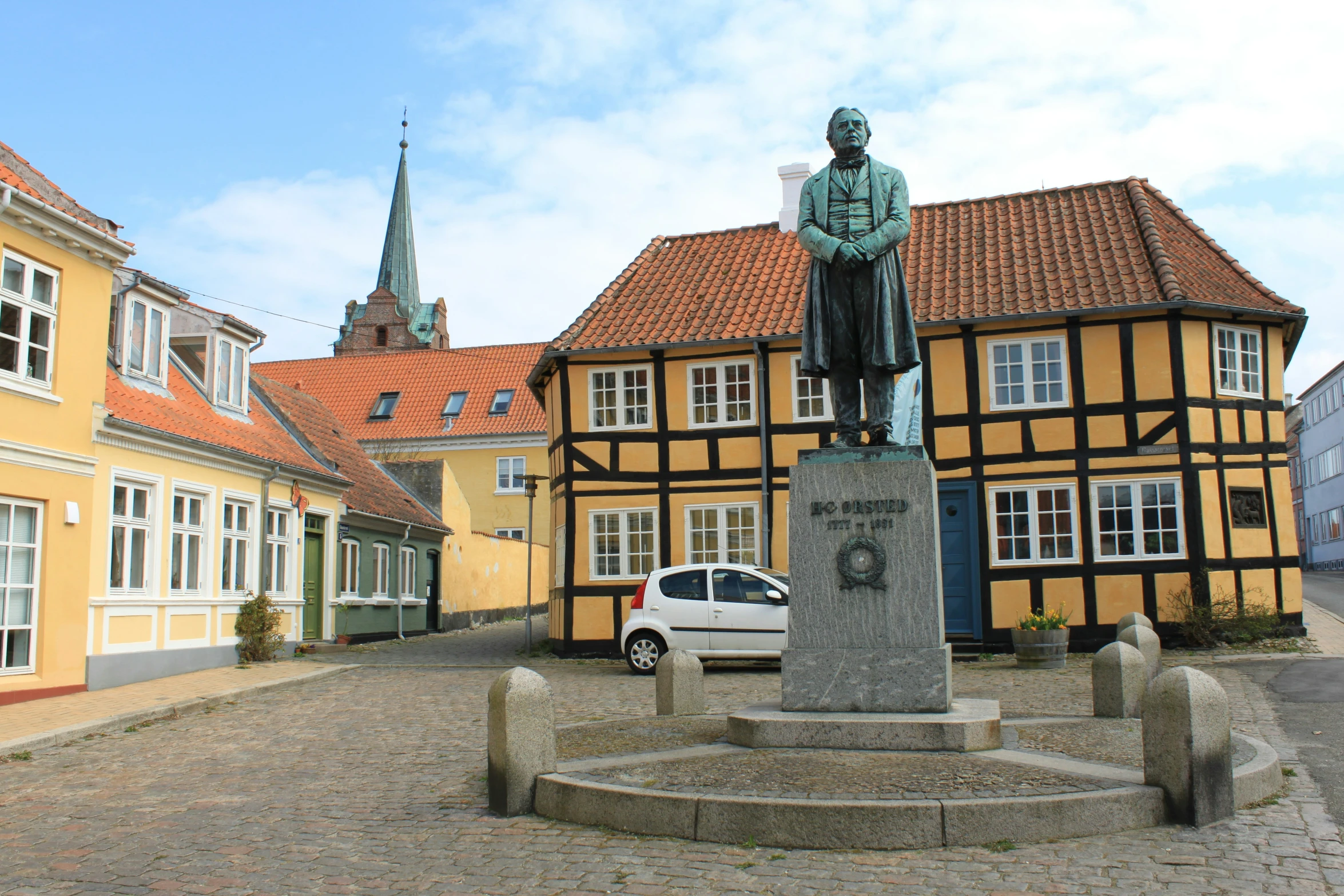 the statue is placed in the middle of a cobblestone street
