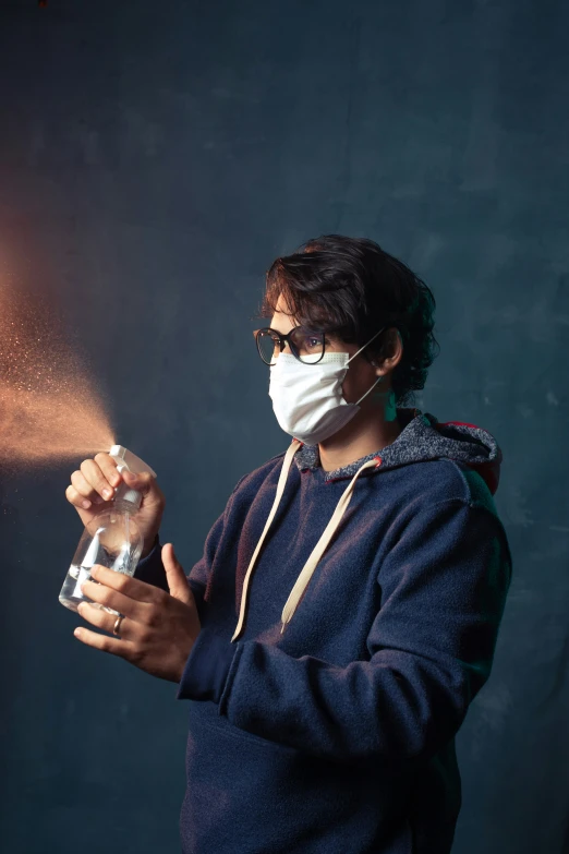 a person in a face mask spraying water on a face