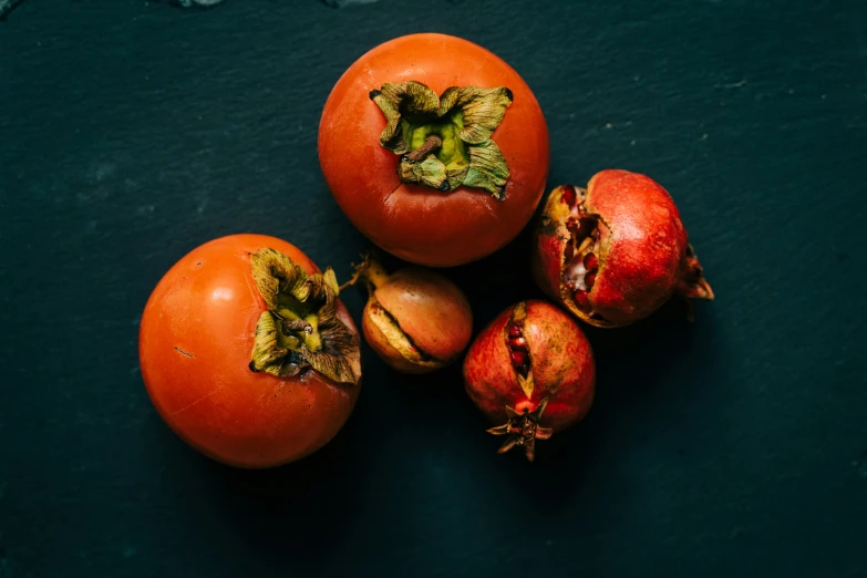 a group of four tomatoes with green leaves and whole  red tomatoes