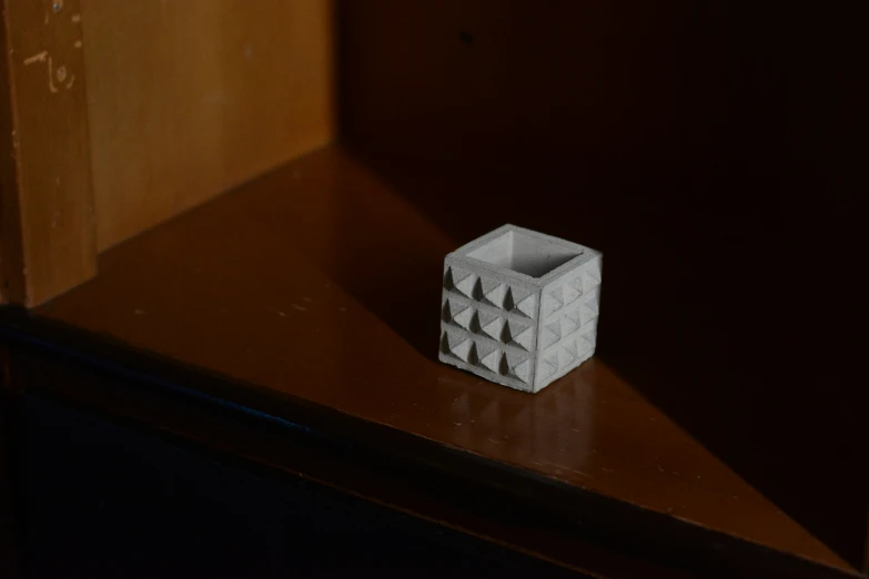 a white cube sits on a wooden table