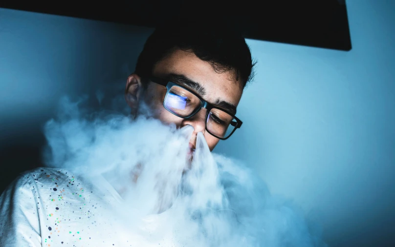 a person standing next to a window with smoke around them