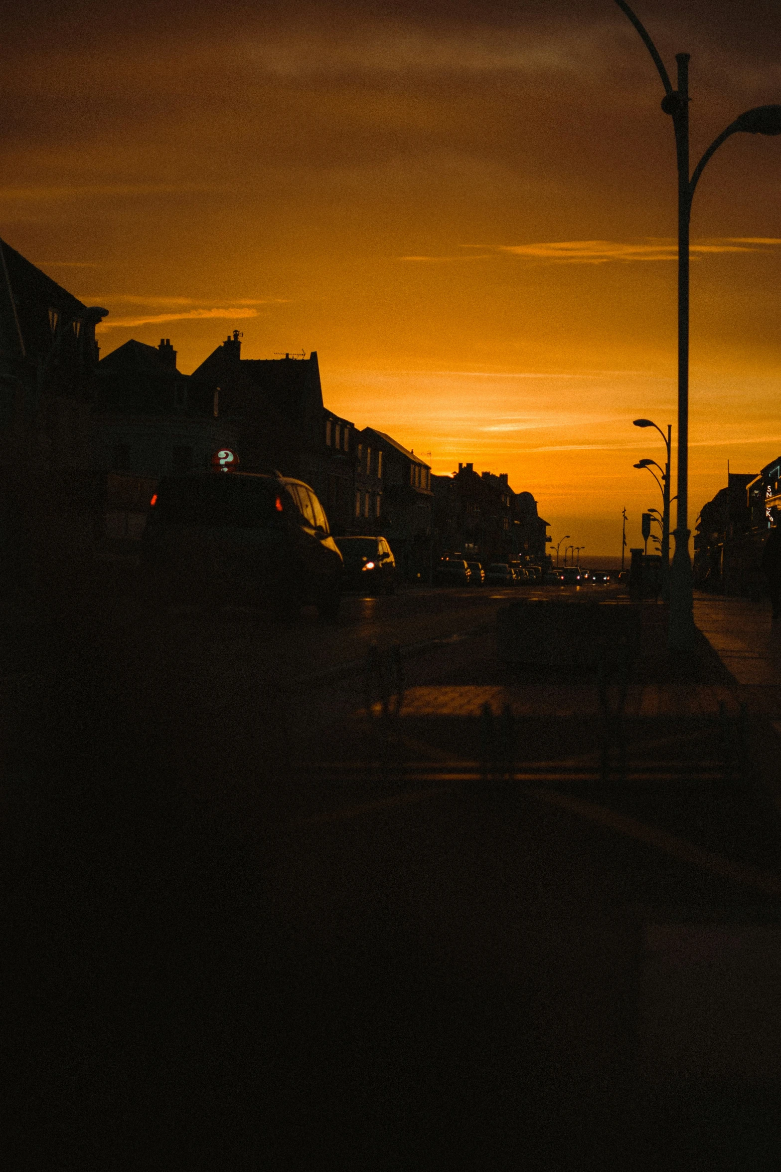 sunset on street with car and truck on road