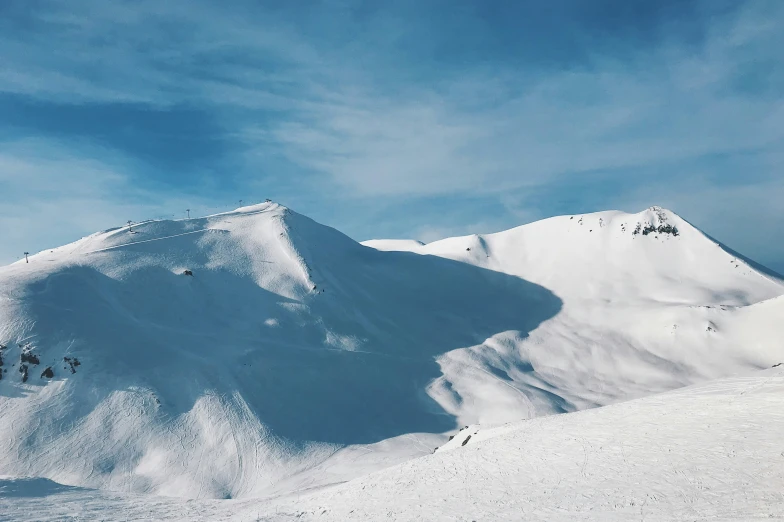 two skiiers are skiing down the snowy mountain