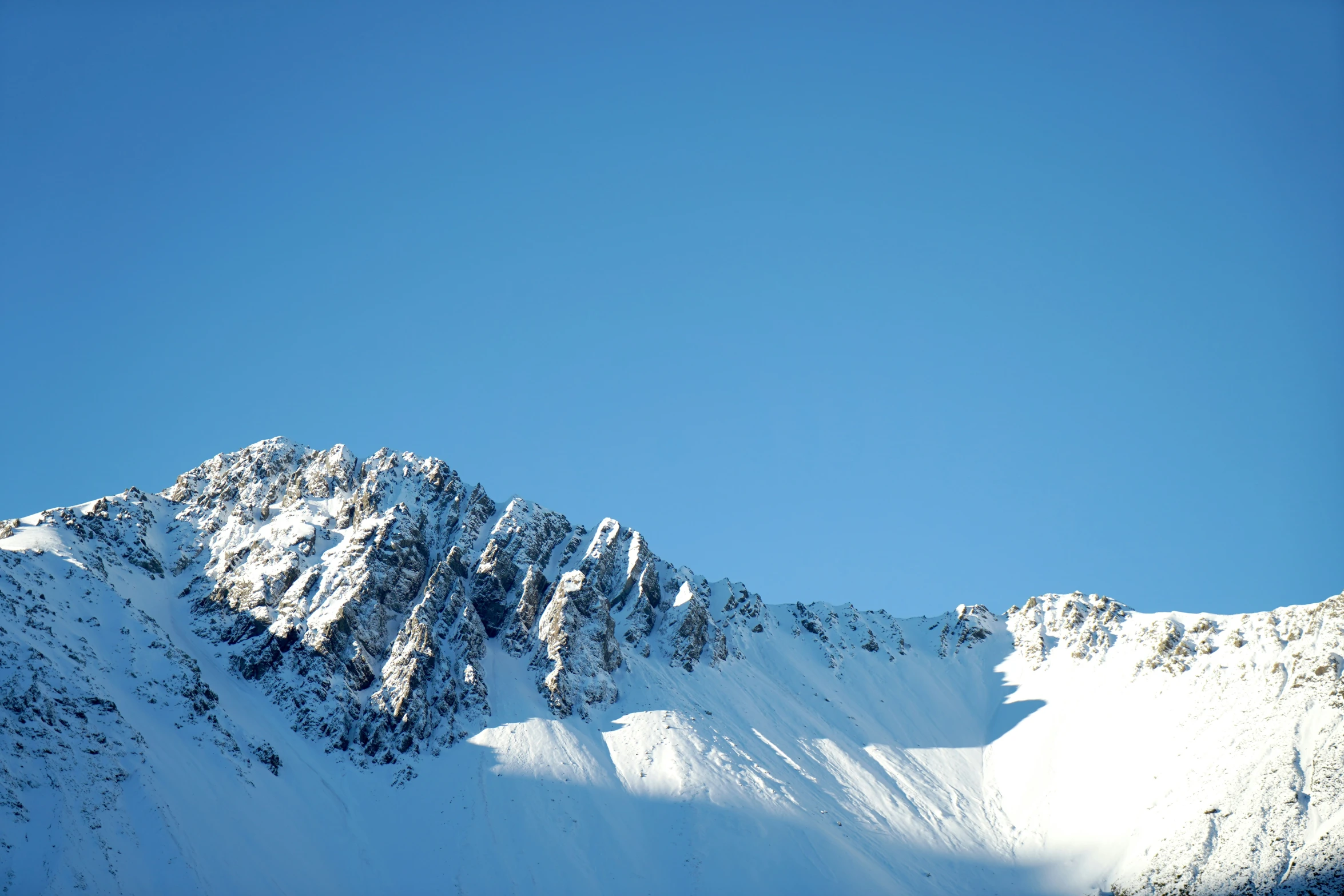 snow on a mountain under a blue sky