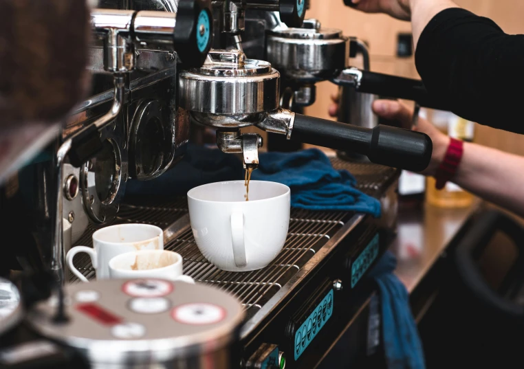 an espresso machine pouring coffee into two cups