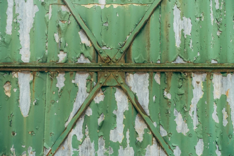 an old green wall with peeling paint