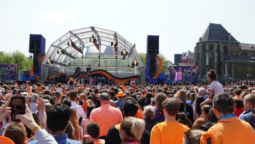 a large crowd is gathered in front of a stage