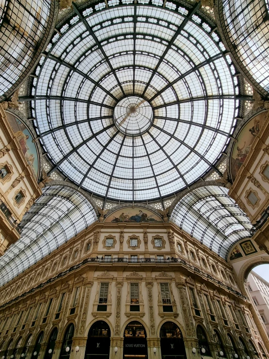 looking up at the ceiling of a building, with several glass windows