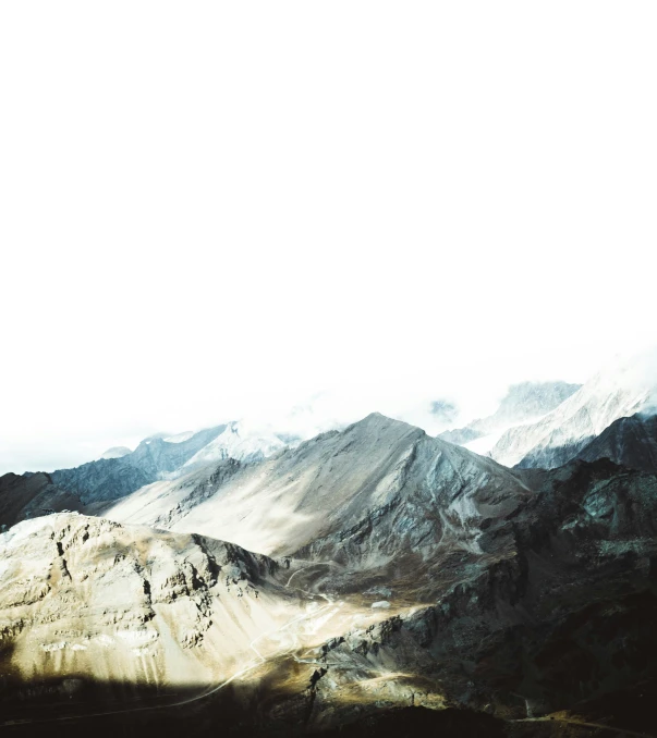 a hill filled with snow covered mountains under a cloudy sky