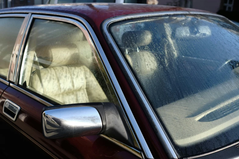 a red car with a beige dog is sitting in the passenger seat