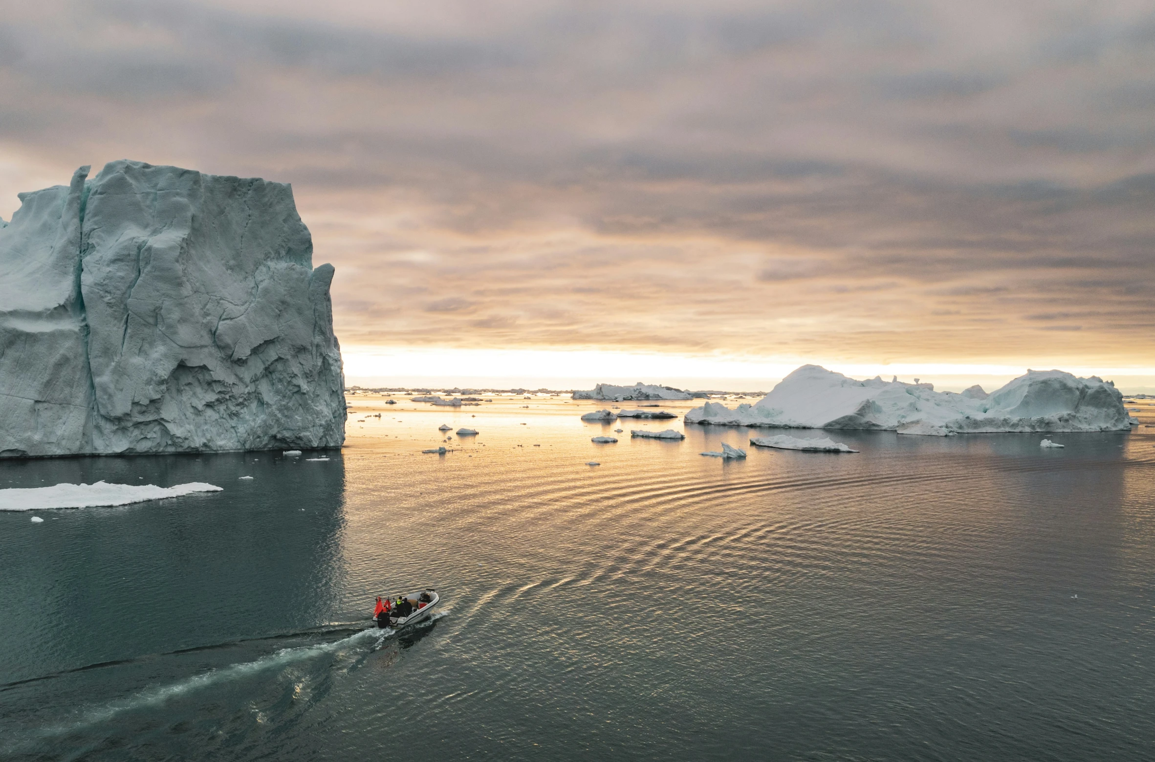 a person in a canoe with icebergs near by