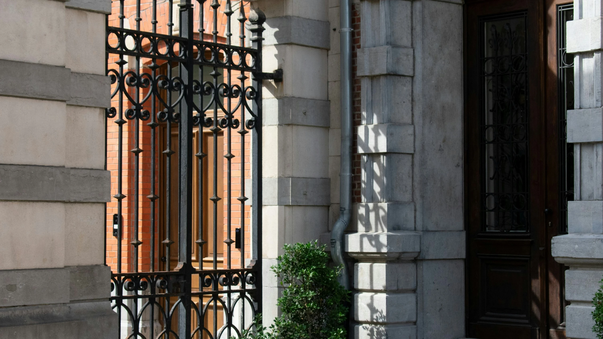 the window is opened on a building that has iron bars