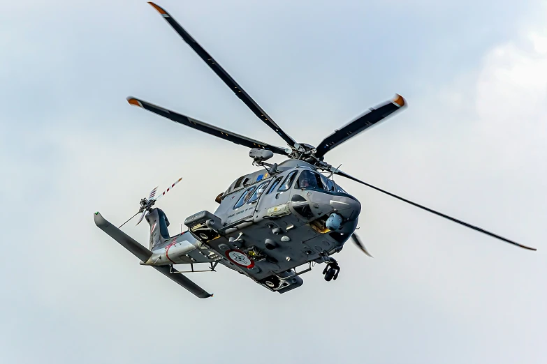 a helicopter flying through the air on a cloudy day