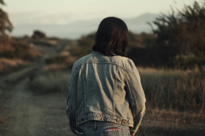 the back view of a person walking on a dirt path