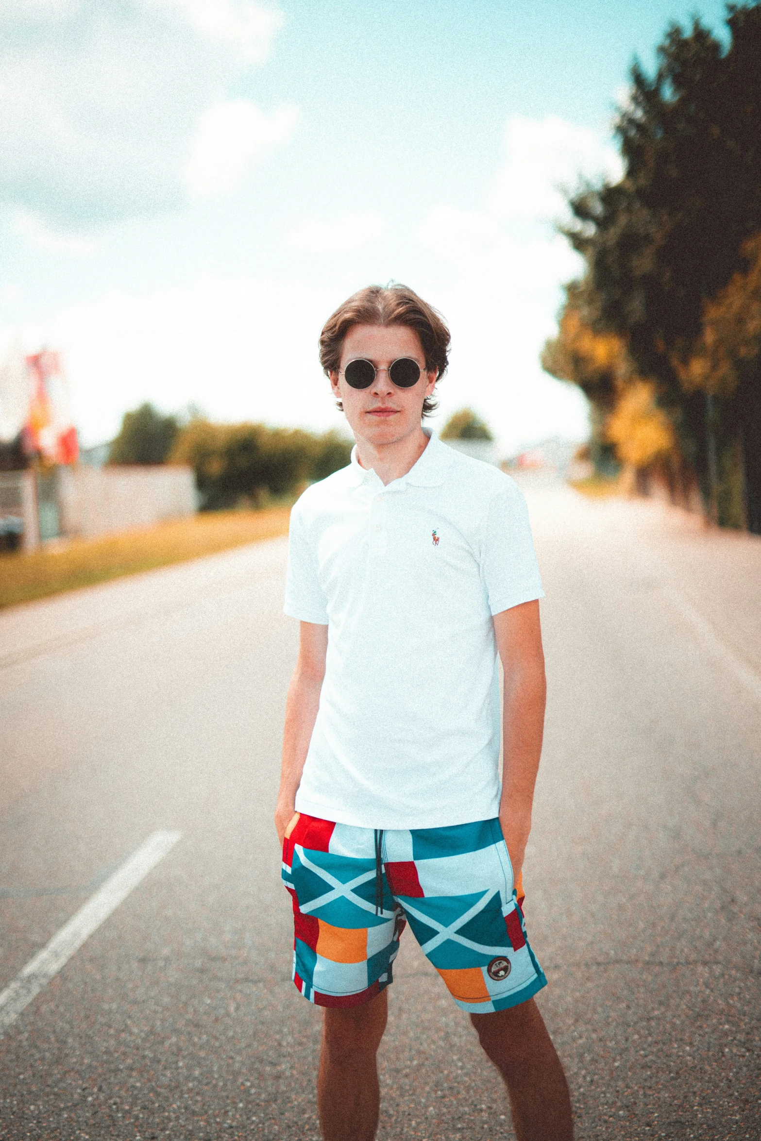 a man posing for a po wearing a pair of sunglasses