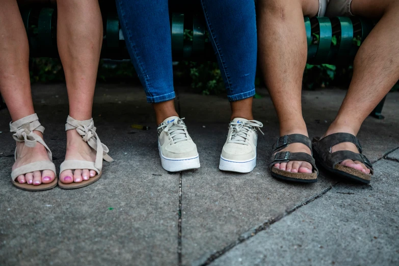 four people wearing shoes on the sidewalk