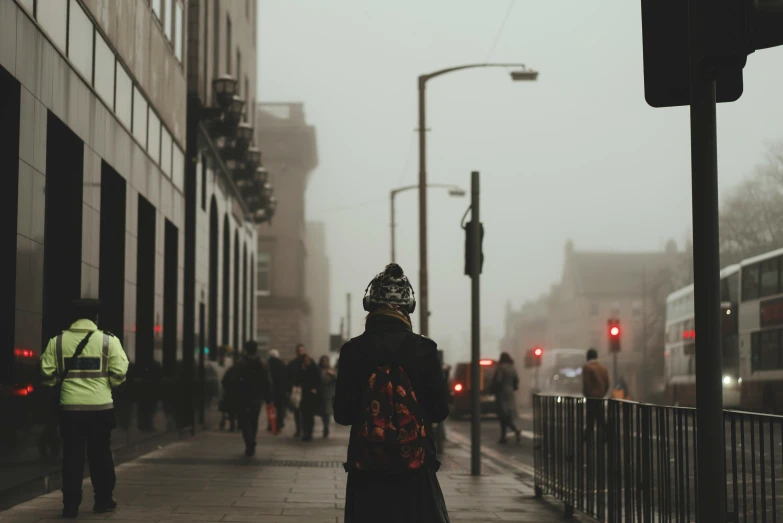 a man standing in front of the traffic lights on a busy street