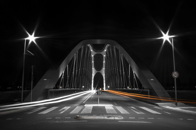 black and white pograph of a bridge at night