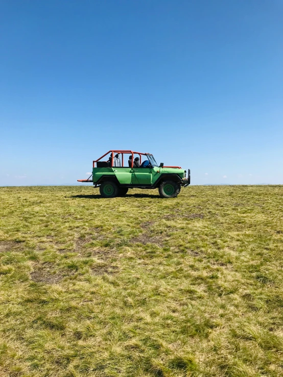 a green vehicle parked on top of a field