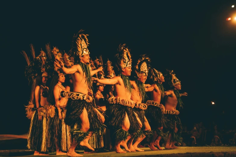 dancers wearing costumes in the dark during a performance