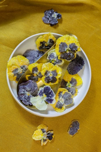 yellow and purple crumbs on a plate of fruit